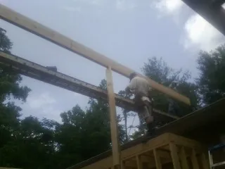 Carpenter setting a ridge beam over a new addition frame — Ice Dam Removal by Roofing Brothers in Townley
