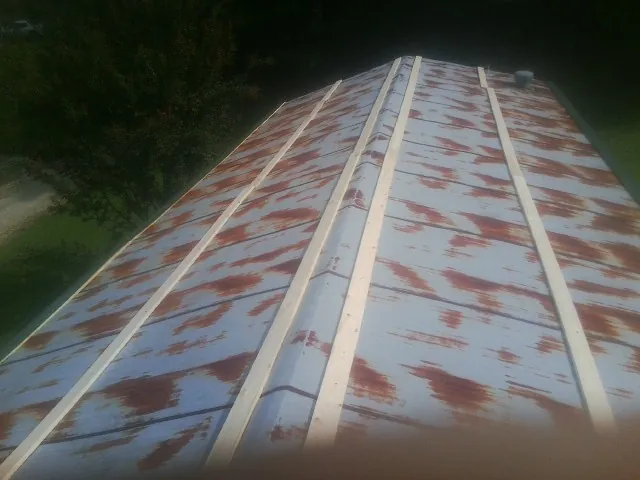Rusted metal roof panels with new wood purlins before replacement — Storm Damage Roof Repair in Townley by Roofing Brothers